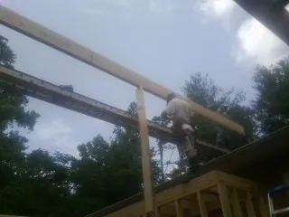 Carpenter setting a ridge beam over a new addition frame — Ice Dam Removal by Roofing Brothers in Hallstead