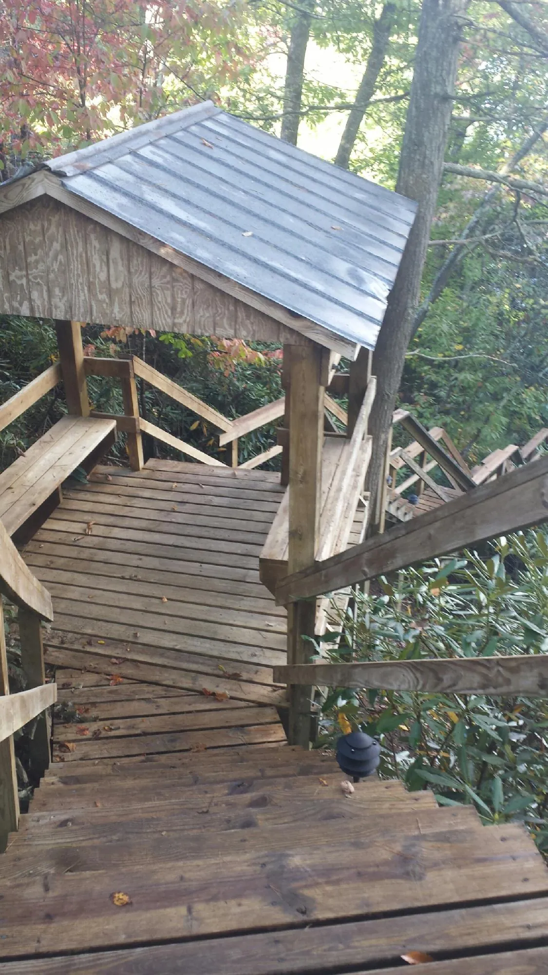Metal roofed shelter over wooden steps on a wooded walkway — Skylight Repair & Installation work by our crew in Hallstead
