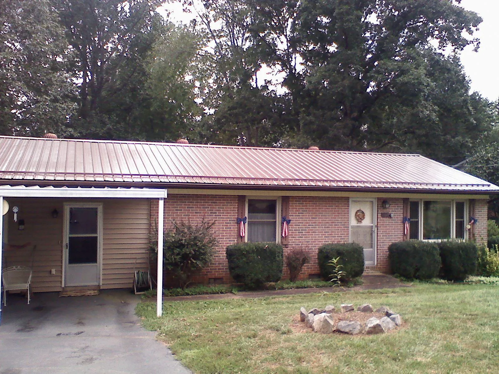 Bronze metal roof and carport on a brick ranch home — Roof Repair work by our crew in Hallstead